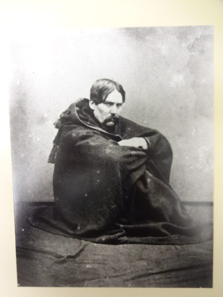 Sir Richard Burton sitting on the floor wearing jubbah with signature