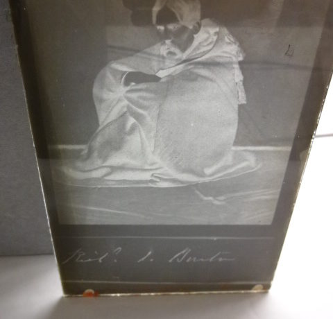Sir Richard Burton sitting on the floor wearing jubbah with signature