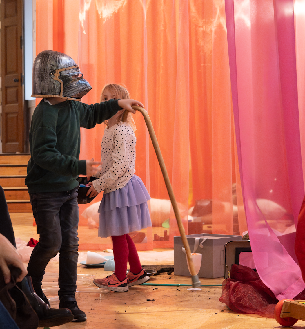 Boy wearing a roman mask and holding a walking stick.